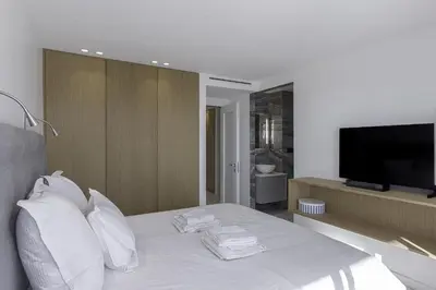 a bedroom with a bed with white pillows and a flat screen tv at Luxury Penthouse Montfleury by Halldis in Cannes