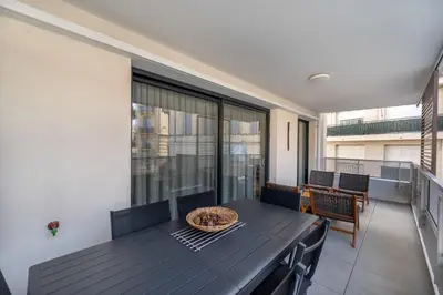 a dining room with a table and chairs on a balcony at C035-Cannes Centre appartement 3 pièces avec parking in Cannes