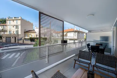 a balcony with two chairs and a large window at C035-Cannes Centre appartement 3 pièces avec parking in Cannes