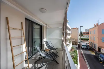 a balcony with chairs and a view of a street at C035-Cannes Centre appartement 3 pièces avec parking in Cannes