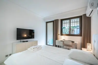 a white bedroom with a large white bed and a desk at Wonderful 2 bedroom apartment in Cannes