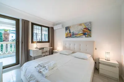 a white bedroom with a large bed and a window at Wonderful 2 bedroom apartment in Cannes