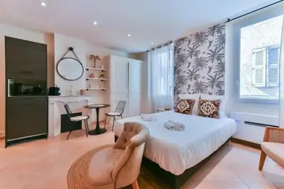 a bedroom with a bed and a table and a kitchen at B062-Studio palais des festivals in Cannes
