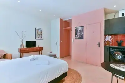 a bedroom with a white bed and a pink door at B062-Studio palais des festivals in Cannes
