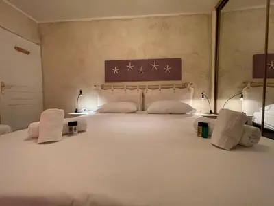 a bedroom with a large white bed with towels on it at Le Suquet Style IV by Connexion in Cannes