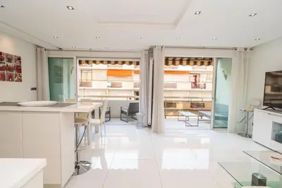 a kitchen with white counters and tables in a room at Croisette 1 mn 2 BR w/ terrace Olam Properties in Cannes