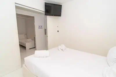a white room with a bed and a flat screen tv at Croisette 1 mn 2 BR w/ terrace Olam Properties in Cannes