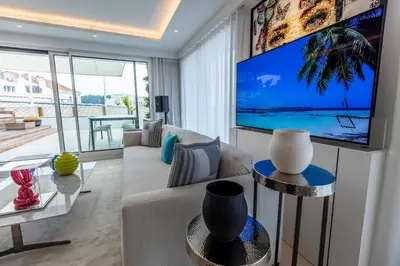 a living room with a couch and a large screen tv at The RoofTop by Connexion in Cannes