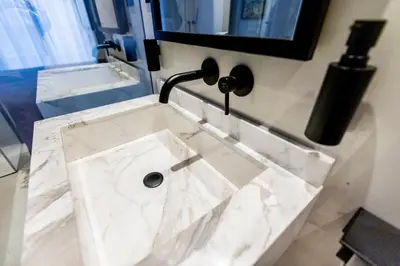 a white marble sink in a bathroom with a faucet at The RoofTop by Connexion in Cannes