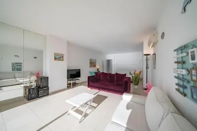 a living room with a purple couch and a table at Beautiful studio with great sea view in Cannes