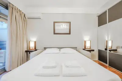 a bedroom with a large white bed with two lamps at Wdf studio right in the heart of Cannes!! in Cannes
