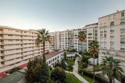 an apartment building with palm trees in front of it at Wdf studio right in the heart of Cannes!! in Cannes