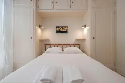 a bedroom with a large white bed with two towels at Wdf one bedroom heart of Cannes in Cannes