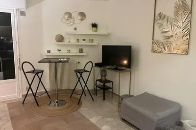 a living room with a tv and a table and chairs at Cannes Croisette Studio 3 pers Cosy CLIM WIFI PKG in Cannes