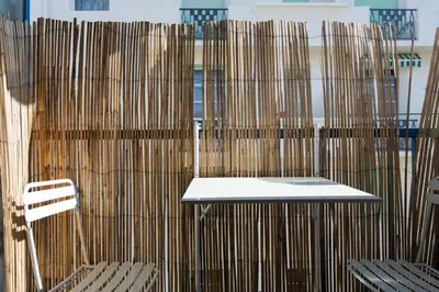 a table and chairs in front of a wooden wall at Cannes Croisette Studio 3 pers Cosy CLIM WIFI PKG in Cannes