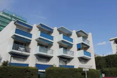 a white apartment building with blue balconies at Cannes Croisette Studio 3 pers Cosy CLIM WIFI PKG in Cannes