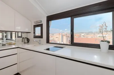 a kitchen with white cabinets and a large window at Wonderful studio heart of Cannes!! in Cannes