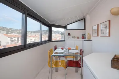 a dining room with a table and chairs and windows at Wonderful studio heart of Cannes!! in Cannes