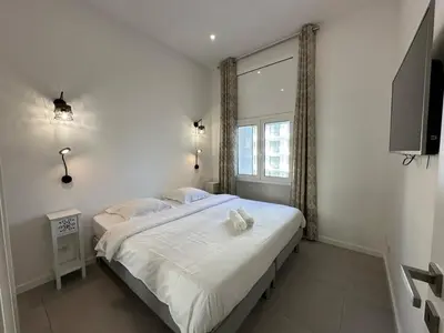 a bedroom with a large bed with a window at B080- À l'étroit à l'hôtel Bienvenue chez nous in Cannes