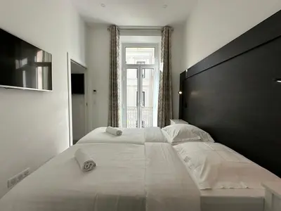 a bedroom with a large bed and a window at B080- À l'étroit à l'hôtel Bienvenue chez nous in Cannes
