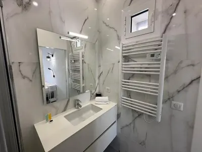 a white bathroom with a sink and a mirror at B080- À l'étroit à l'hôtel Bienvenue chez nous in Cannes