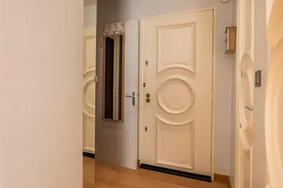 a door in a hallway with white walls and wooden floors at Bright 2bedroom apartment 15min walk to the Palais in Cannes