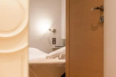 a door leading to a room with a bed and a mirror at Bright 2bedroom apartment 15min walk to the Palais in Cannes