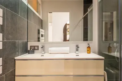 a bathroom with a sink and a mirror at Bright 2bedroom apartment 15min walk to the Palais in Cannes