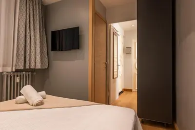 a bedroom with a bed and a television on the wall at Bright 2bedroom apartment 15min walk to the Palais in Cannes