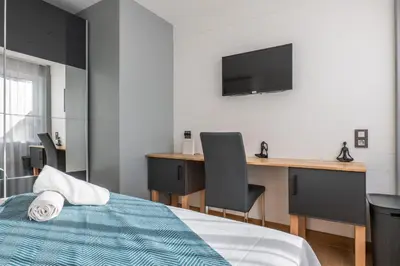 a bedroom with a bed and a desk and a television at Bright 2bedroom apartment 15min walk to the Palais in Cannes