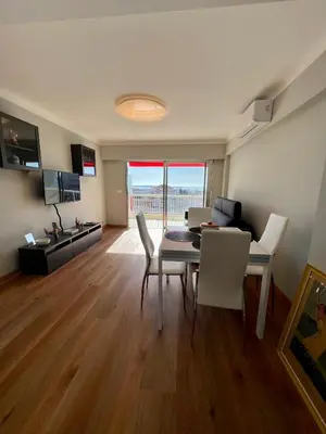 a living room with a table and chairs and a kitchen at Cannes Santa Catalina in Cannes