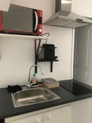 a kitchen counter with a sink and a microwave at Studio cosy en plein centre-ville in Cannes
