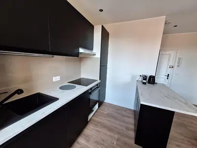 a kitchen with black cabinets and a counter top at Appartement comme une suite d’hôtel in Cannes