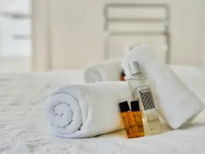 a towel and cosmetics sitting on a bed at Le Guynemer - Appartement Beaux Arts Cannes in Cannes
