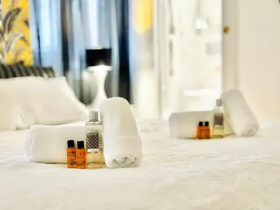 a bed with towels and bottles of essential oils on it at Le Guynemer - Appartement Beaux Arts Cannes in Cannes
