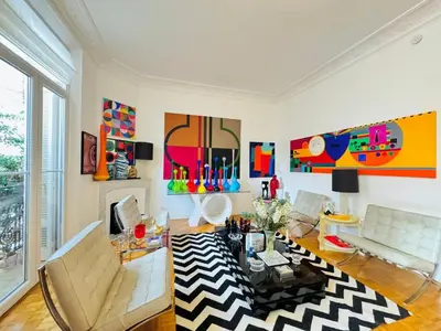 a living room with a couch and a table at Le Guynemer - Appartement Beaux Arts Cannes in Cannes