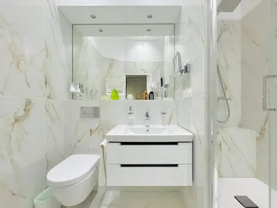a white bathroom with a toilet and a sink at Le Guynemer - Appartement Beaux Arts Cannes in Cannes