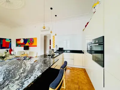 a kitchen with a large marble table and chairs at Le Guynemer - Appartement Beaux Arts Cannes in Cannes
