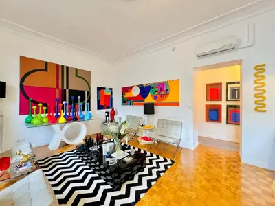 a living room with a black and white rug at Le Guynemer - Appartement Beaux Arts Cannes in Cannes