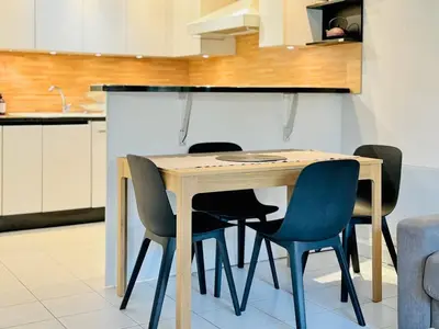 a kitchen with a wooden table and chairs at Le Jardin Gallieni - Terrasse Cozy in Cannes