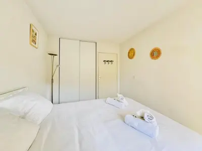 a white bedroom with two towels on a bed at Le Jardin Gallieni - Terrasse Cozy in Cannes