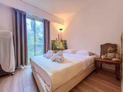 a bedroom with a bed with a teddy bear on it at Terrasse Vue Mer - A quelques minutes de Cannes in Le Cannet