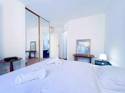a bedroom with a white bed with two towels on it at Terrasse Vue Mer - A quelques minutes de Cannes in Le Cannet