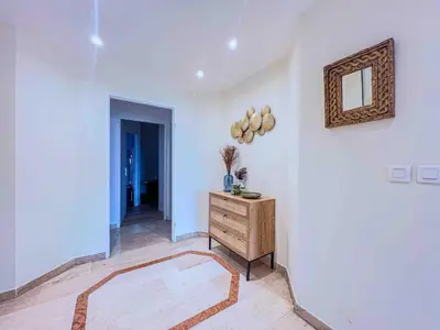 a white room with a wooden dresser and a mirror at Terrasse Vue Mer - A quelques minutes de Cannes in Le Cannet