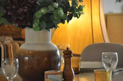 a vase sitting on a table with wine glasses at Terrasse Vue Mer - A quelques minutes de Cannes in Le Cannet