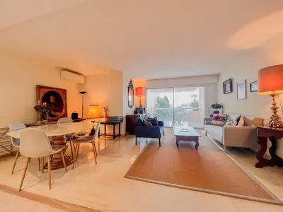 a living room with a table and a couch at Terrasse Vue Mer - A quelques minutes de Cannes in Le Cannet