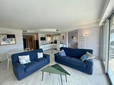 a living room with two blue couches and a table at Le President II by Connexion in Cannes