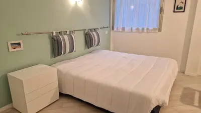 a bedroom with a bed with a white blanket on it at Le President II by Connexion in Cannes