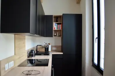 a kitchen with black cabinets and a stove at T2 Cannes centre in Cannes