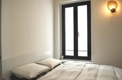 a bed with two pillows in a room with a window at T2 Cannes centre in Cannes